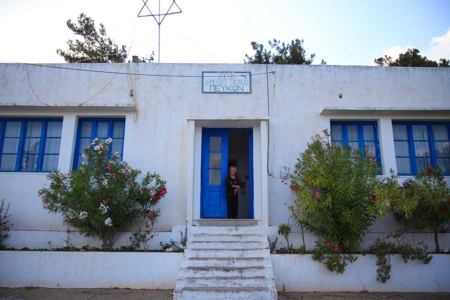 The old two-seated primary school of Pefki with mrs. Ourania at the entrance.